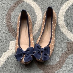 Tan and white polka dot flats with a bow